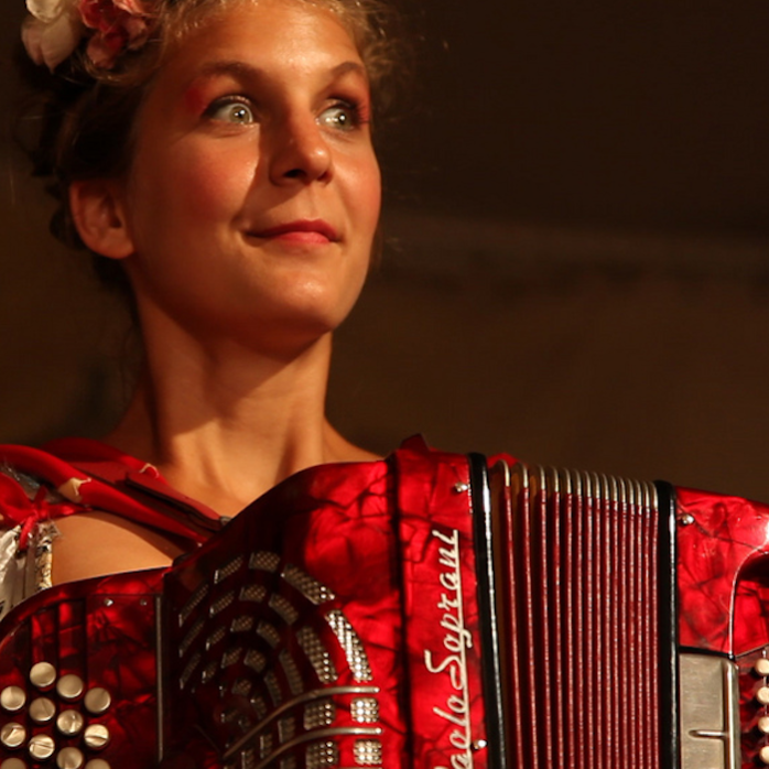 Beautiful Circus Musician in place with Red Accordion, Russian culture.