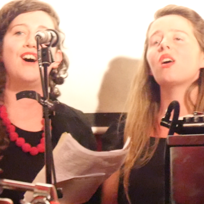 Two females singers performing songs by Sarah Llewellyn at her album Tonal 10 launch show.