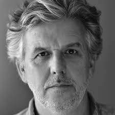 Black and white head shot of white man in his 50s looking to camera.